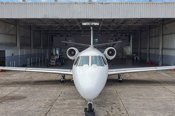 Avião em frente ao hangar